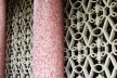 Fachada lateral externa. Muxarabis em formatos de flor-de-lis e colunas revestidas com pastilhas cor de rosa.