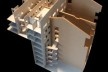 Vista da maquete em construção onde se nota a implantação da proposta sobre a estrutura preexistência (o terreno em dois níveis separados por uma contenção e as paredes divisórias entre as quatro casas), bem como os pátios internos e as passarelas