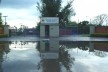 Portão da Escola Santo Inácio, prevista para ser demolida. Ao fundo, vêem-se os prédios da Escola. Observa-se como a área é alagadiça
