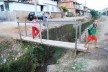 Crianças em pinguela sobre o córrego Monte Alegre e aspecto do bairro de mesmo nome, com problemas ambientais entre outros
