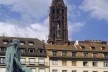 Estátua de Gutenberg segurando nas mãos uma página do primeiro livro impresso em Mainz – a Bíblia – onde está escrito: “Et la lumière fut”; ao fundo, torre da Catedral de Notre-Dame de Strassbourg