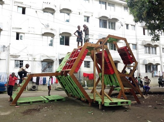 The architects used pallets and plastic crates to create a playground with benches and vertical gardens in the plastic crates