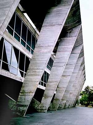 Museu de Arte Moderna do Rio de Janeiro, Affonso Eduardo Reidy, 1953. O MAM é um exemplo de resposta inventiva do arquiteto às demandas de uso, do lugar e da construção. A estrutura externa em pórticos que atiranta a laje do segundo pavimento permite a li
