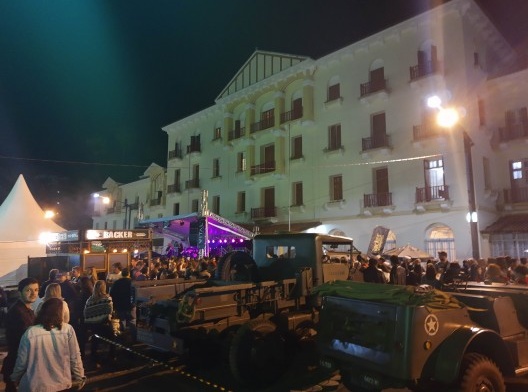 Carros militares expostos e tendas para a venda de alimentos durante evento de exposição de carros antigos