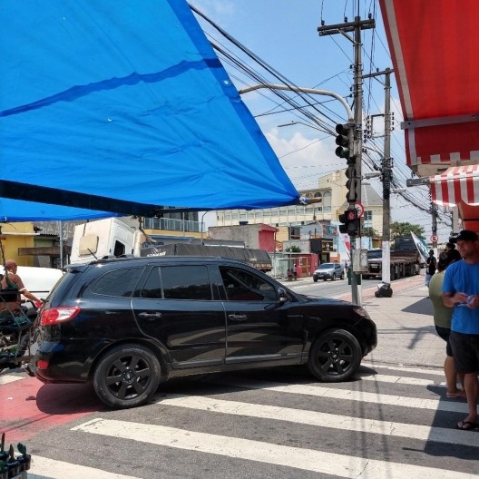 Veículo estacionado entre a faixa de pedestres e a ciclofaixa, no acesso à feira na esquina da Rua Santa Rosa de Lima com a Av. Oliveira Freire