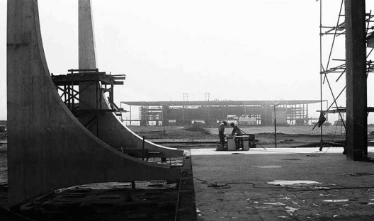 Palácio do Planalto visto do peristilo do Palácio do Supremo alguns dias antes da abertura do Congresso, quando o revestimento das colunas e o assentamento das pedras do piso estão em execução, 03/09/1959