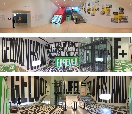 Museu Stedelijk, Amsterdam, escadas no hall conectam com o piso intermediário, onde está a instalação de Barbara Kruger
