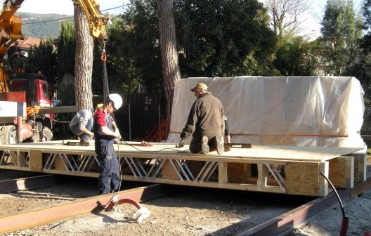 Colocação das vigas tipo I sobre placas de aço assentadas sobre lastro compactado e colocação dos painéis da plataforma no canteiro de obras