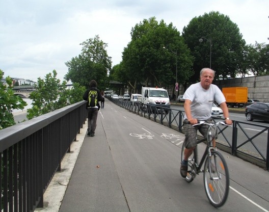 Homem andando de bicicleta em ciclovia de Paris
