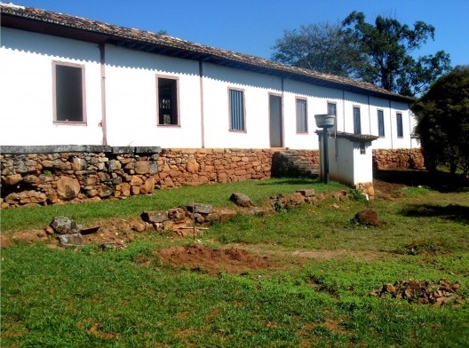 Gramado beirando a fachada lateral esquerda da sede da fazenda