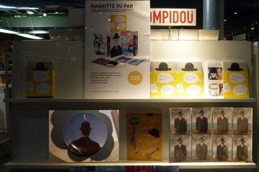 Poirot já viu as exposições em cartaz e só quer comprar uma lembrança para a esposa antes de voltar para casa, em Lessines, terra natal de René François Ghislain Magritte, um dos principais artistas surrealistas belgas.