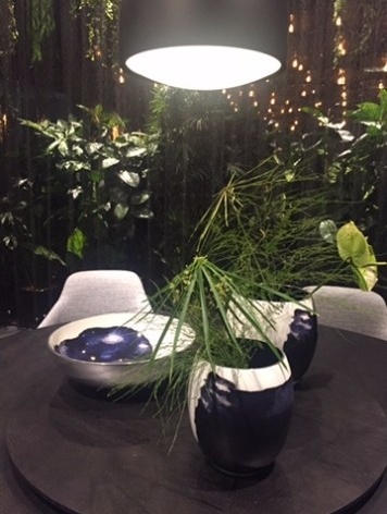 Salone del Mobile Milano 2017. Stand da mostra principal mostra as características das ambientações em voga: Tons de azul e verde, uso de plantas e materiais naturais na decoração