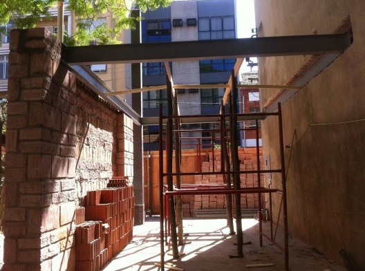 Estrutura metálica pronta para receber laje pré-fabricada de vigota e tavela. A empena antiga foi demolida no térreo após a viga metálica ser duplada pelo lado de dentro devido a espessura da parede