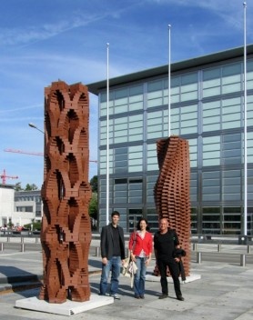 Duas colunas de tijolos construídas pelo robô do Dfab e expostas no campus da ETH. Da esquerda para a direita, Silvan Oesterle (ETH), Gabriela Celani (Unicamp) e José Beirão (TUDelft/UTL)