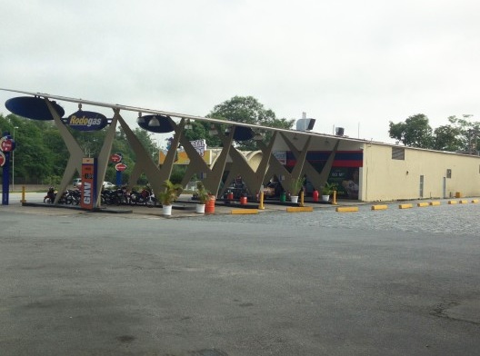 Integração de uma coluna em K (mais a direita) à fachada da loja de conveniência e sinalização inadequada