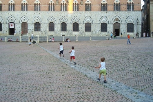 Crianças transformam a canaleta de captação de água de chuva em percurso lúdico