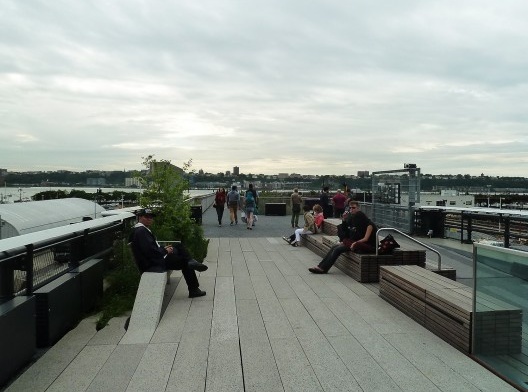 Levanta-se de abrupto e retoma célere sua caminhada; o detetive novato quase perde de vista a garota de cabelo azul, que se mistura com os transeuntes.