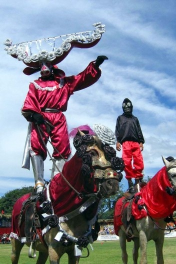Mascarados em posição de respeito durante o Hino do Divino