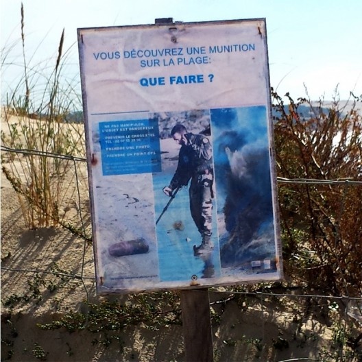 Placa com aviso de minas e bombas que ainda podem ser encontradas na costa, proximidades da pequena localidade de Plage du Pin-Sec