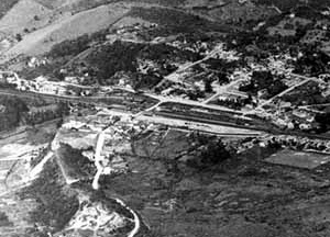 Ao fundo, Núcleo Colonial, ferrovia e páteo ferroviário Em primeiro plano, Rua do Comércio e Morro de Santo Antônio (removido), vôo sem data