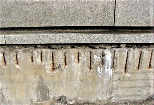 Danos estruturais — carbonatação e cobertura de concreto insuficiente para o reforço das paredes de concreto na base do edifício