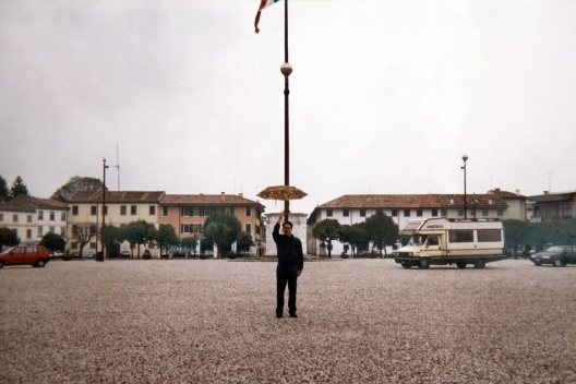 Renato Anelli, com guarda-chuva, na praça central de Palmanova, 1994