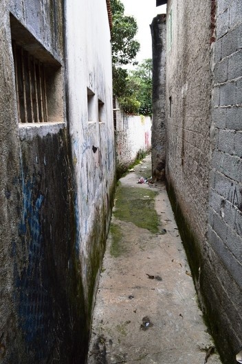 Córrego oculto, janelas abertas ao improviso parecem espiar, curiosas, os vestígios do córrego tamponado