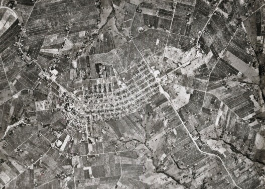 Aerofoto de Pérola, 1980: simetria e inflexão da forma devido à nascente próxima. Ponto focal e vias radiais: a avenida central se abrindo em vias radiais. Projeto do engenheiro civil Arthur Bruno Junges (Universidade do Paraná), 1953