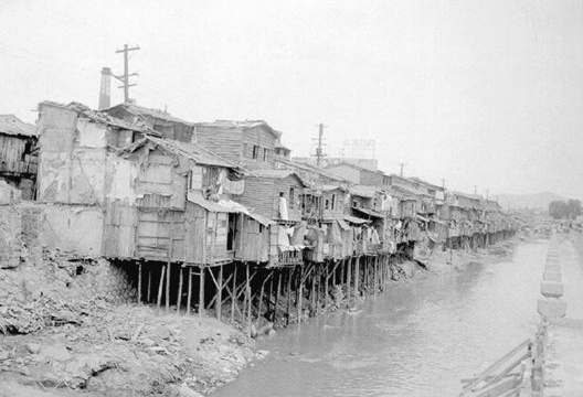Favelas ao longo do rio construídas por refugiados da Guerra das Coreias, por volta de 1950