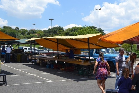 Processo de desmontagem de uma barraca: retirada da cobertura que é desacoplada das pontas das terças da estrutura da cobertura