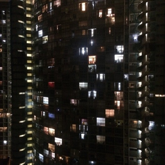 Seu edifício está ainda quase todo iluminado, mesmo com a madrugada já avançada.