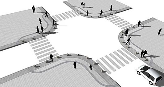 As esquinas são rebaixadas, configurando amplas rampas delimitadas pela faixa de piso tátil e pelos balizadores esféricos. Tornam-se imperceptíveis ao usuário por sua suavidade e pela continuidade do desenho do piso e da faixa de mobilliário