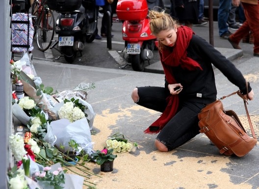 Homenagem aos mortos na frente do restaurante Le Petit Cambodge um dia após o atentado