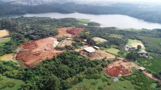 Em área de preservação ambiental em beira da represa, movimentação de terra em terreno usado para descarte de entulho e material de construção civil