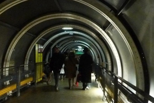 A pessoa entra no equipamento cultural e, no impulso e sem pestanejar, o jovem arquiteto abandona os souvenirs que já havia escolhido e segue o personagem de trajes pretos.