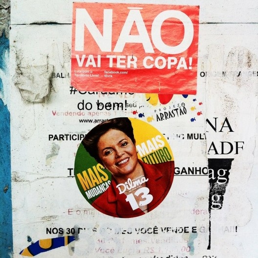 Adesivos da campanha eleitoral de 2014 e das manifestações de 2013 em poste de ponto de ônibus