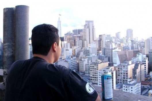 Djan Ivson Silva, o Cripta Djan, mirando a cidade do alto de um edifício em São Paulo