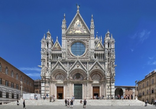 Como não a encontrou no interior, se postou diante do acesso principal, onde poderia observar a magnífica edificação sem perder de vista a chegada de sua bela amada.