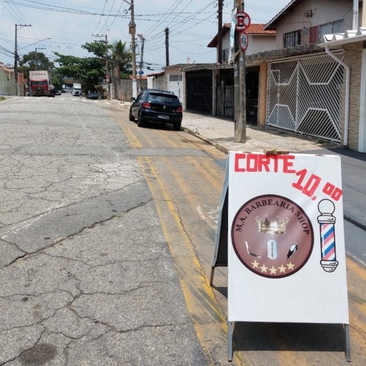 Ciclofaixa ocupada por automóvel e placa de publicidade na Rua Santa Rosa de Lima, entre a linha férrea e a Av. Marechal Tito