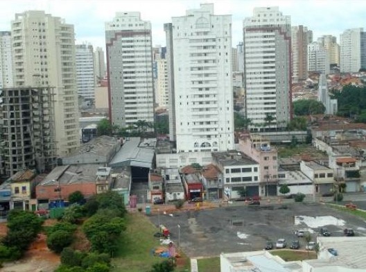 Paisagem vertical da Mooca: novos edifícios, casas e comércios em deterioração e a Igreja São Rafael, ícone da história local, ilhada. Foto de jan. 2011
