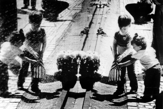 Filhos de soldados americanos mortos na guerra depositam flores diante do Memorial do Vietnã, em Washington