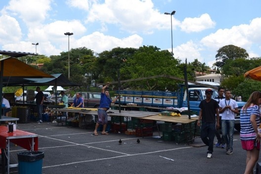 Processo de desmontagem de uma barraca: retirada da estrutura do telhado, terças e cumeeiras, que são compactadas na carroceria do caminhão