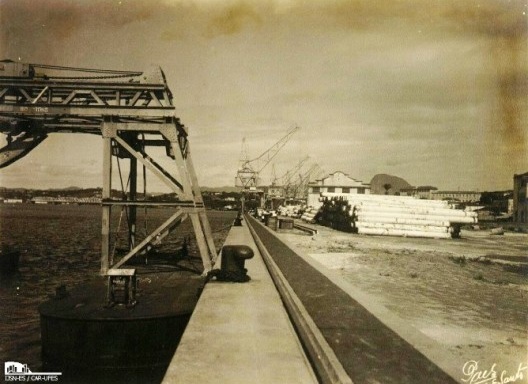 Plataforma em aterro com equipamentos e armazéns portuários ao fundo (1936)