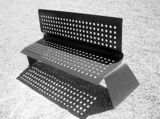 Vista geral de um modelo de banco público com design contemporâneo, presente no Vondelpark, em Amsterdam, na Holanda