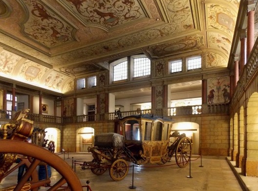 Vista interna do primeiro Museu Nacional dos Coches, que segue funcionamento com parte do acervo. O pé-direito duplo e a galeria de circulação em mezanino foram adotados no projeto do novo museu, assinado por Mendes da Rocha e equipe