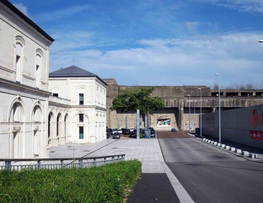 O prédio da antiga estação ferroviária transformado em teatro com o bunker ao fundo