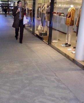 Piso com fotografias históricas da cidade, impressas em placas de concreto, ao longo do eixo principal, obra de arte de Thomas Ruff