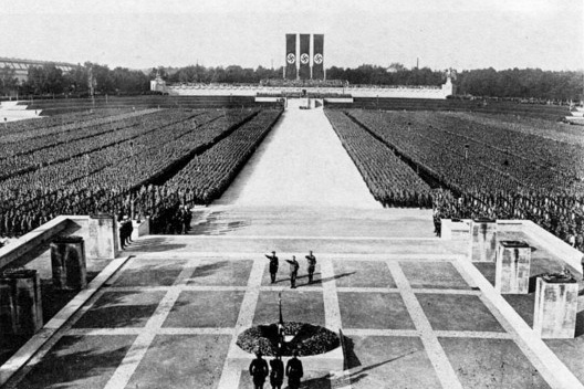 Cena de \"O triunfo da vontade\", filme de Leni Riefenstahl sobre o 6º Congresso do Partido Nazista, no Zeppelinfeld, imensa tribuna construída por Speer em Nuremberg. A organização da cerimônia coube a Speer
