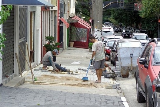 Pedreiros refazem a calçada