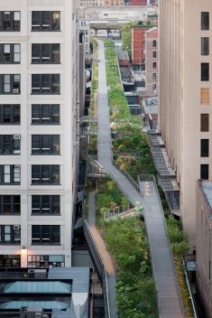 Falcone Flyover, an elevated pathway passes between historic warehouse buildings, between West 25th and West 27th Streets, looking North